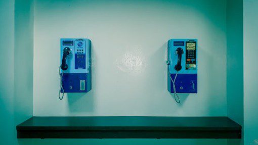 Blue payphones in a blue booth