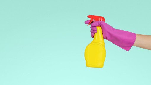 person holding a yellow plastic spray bottle