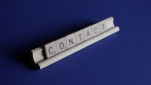 Contact spelled out in wooden Scrabble tiles