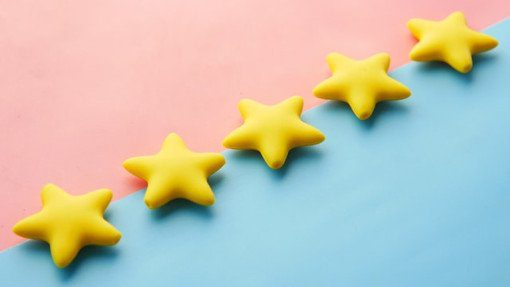 Five yellow plastic stars on a pink and blue background